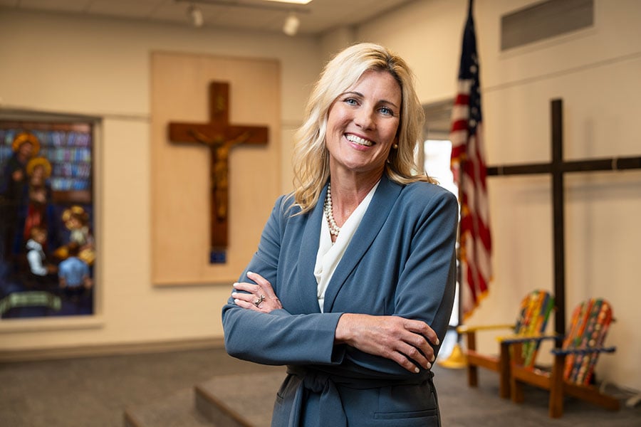 Dr. Kasemeier stands amongst students in front of Holy Family Catholic School